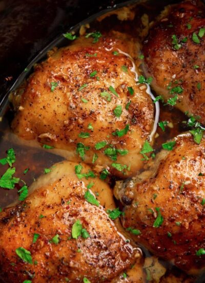 Slow cooker brown sugar garlic chicken in a crock pot topped with fresh parsley.