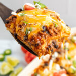 A hearty serving of Mexican ground beef casserole on a wooden spatula.
