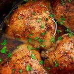 Slow cooker brown sugar garlic chicken in a crock pot topped with fresh parsley.
