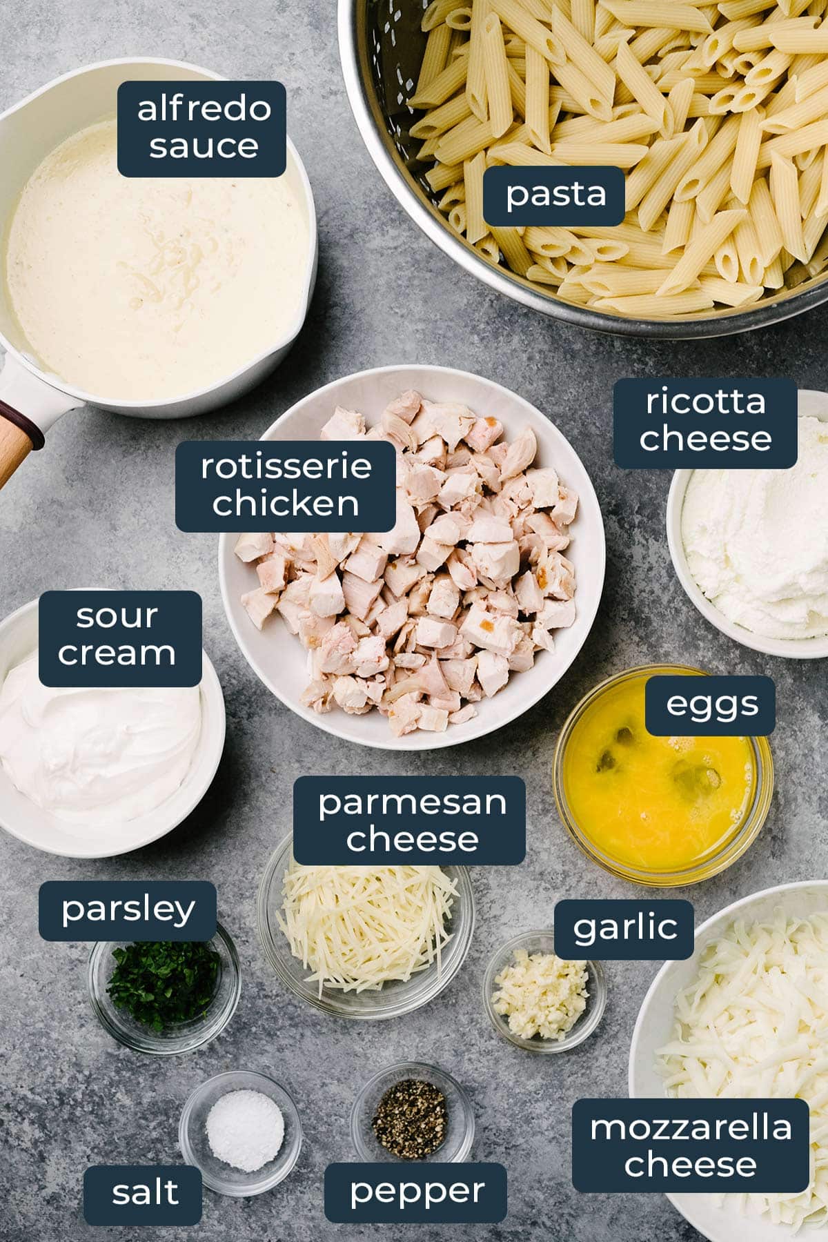 Ingredients to make chicken Alfredo pasta bake in prep bowls.