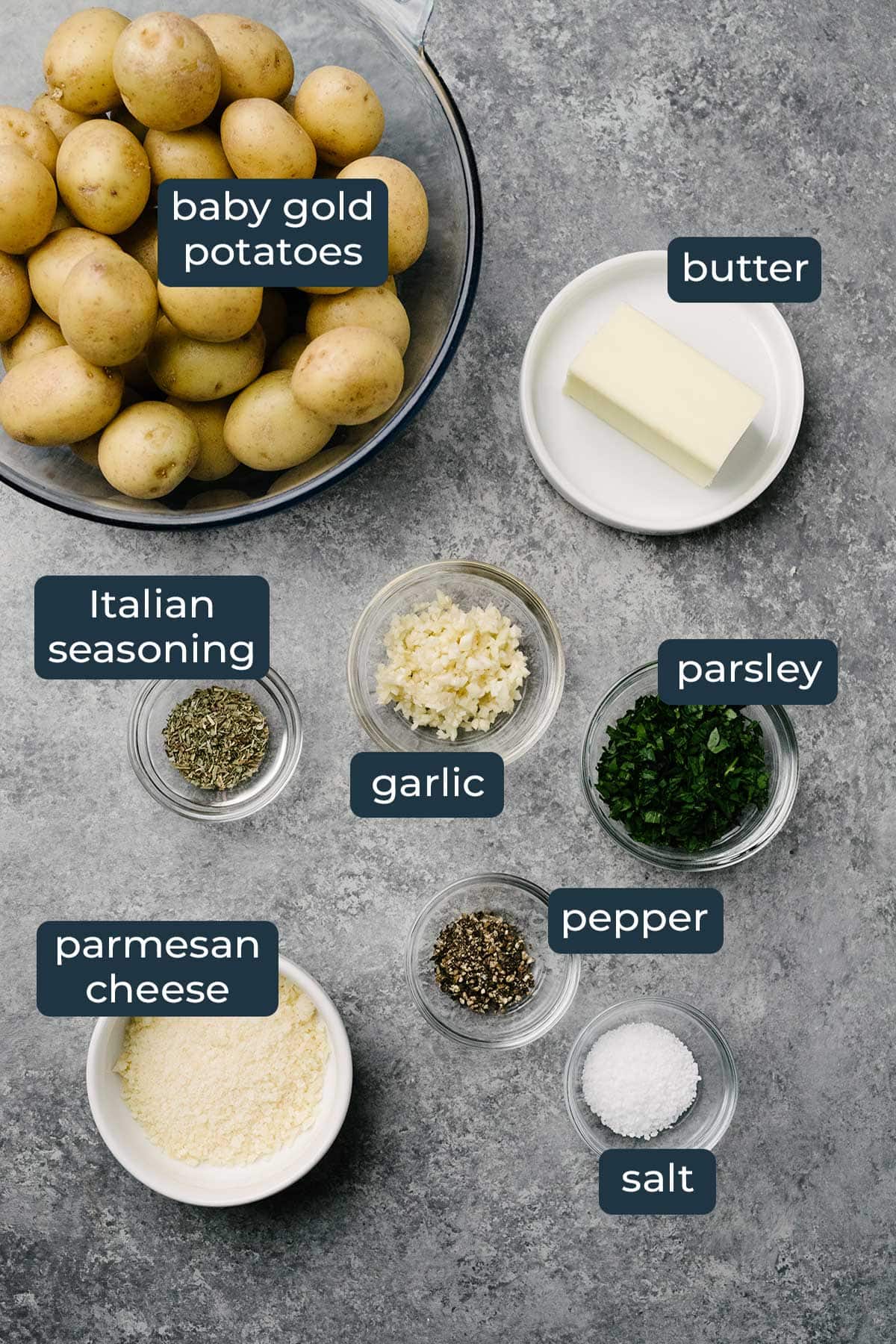 Ingredients to make crispy garlic Parmesan smashed potatoes in prep bowls.