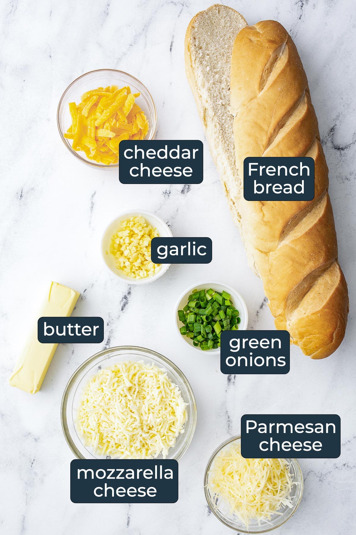 Ingredients to make cheesy garlic bread in prep bowls.