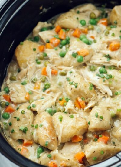 A close up photo of slow cooker chicken and dumplings in a crockpot.