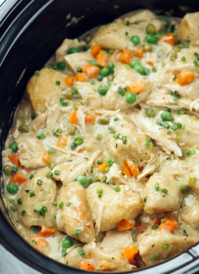 A close up photo of slow cooker chicken and dumplings in a crockpot.