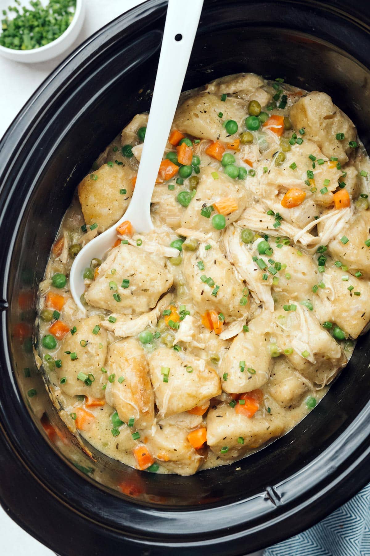 Cooked crockpot chicken and dumplings in a slow cooker.