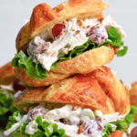 Two chicken salad croissant sandwiches stacked on top of each other.
