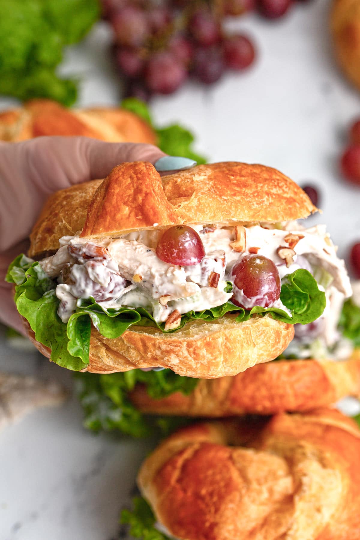 A generously packed chicken salad croissant sandwich.