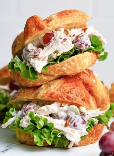 Two chicken salad croissant sandwiches stacked on top of each other.