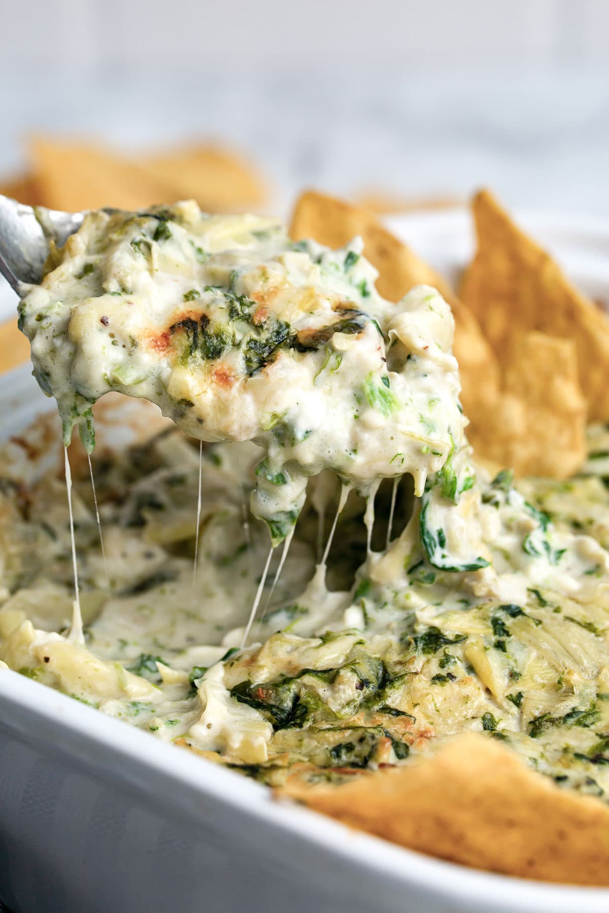 Lots of cheese strings from a hearty spoonful of spinach and artichoke dip lifted from the baking dish.
