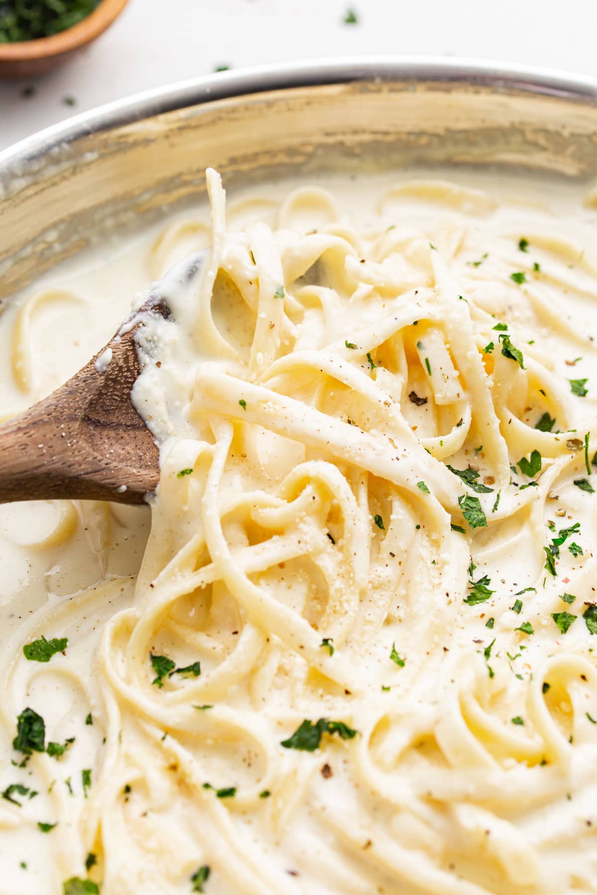 Fettucine pasta smothered in homemade Alfredo sauce and topped with fresh parsley.