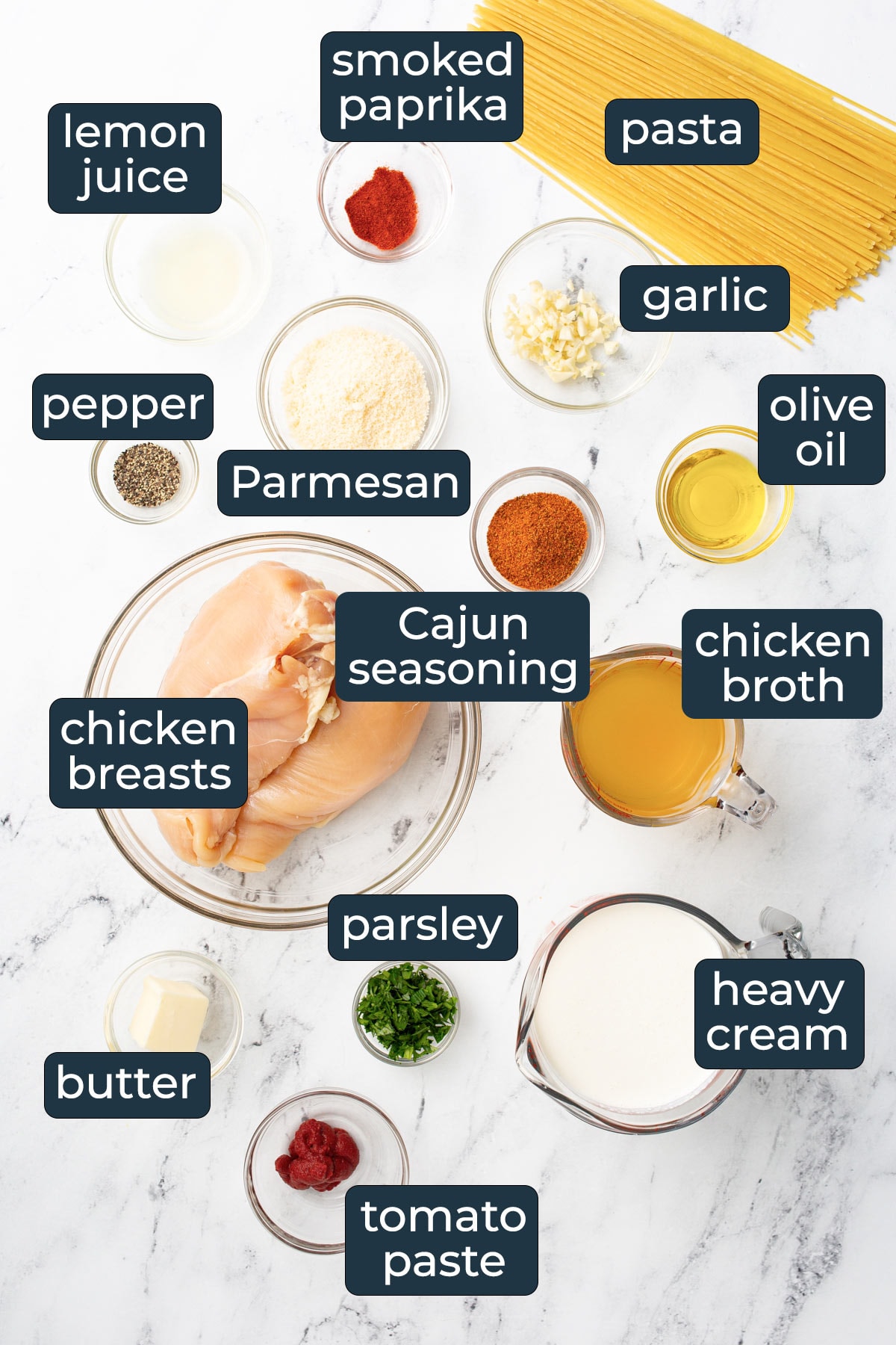 Ingredients for making creamy Cajun chicken pasta in prep bowls.
