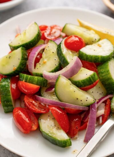 Cucumber tomato salad served on a white plate.
