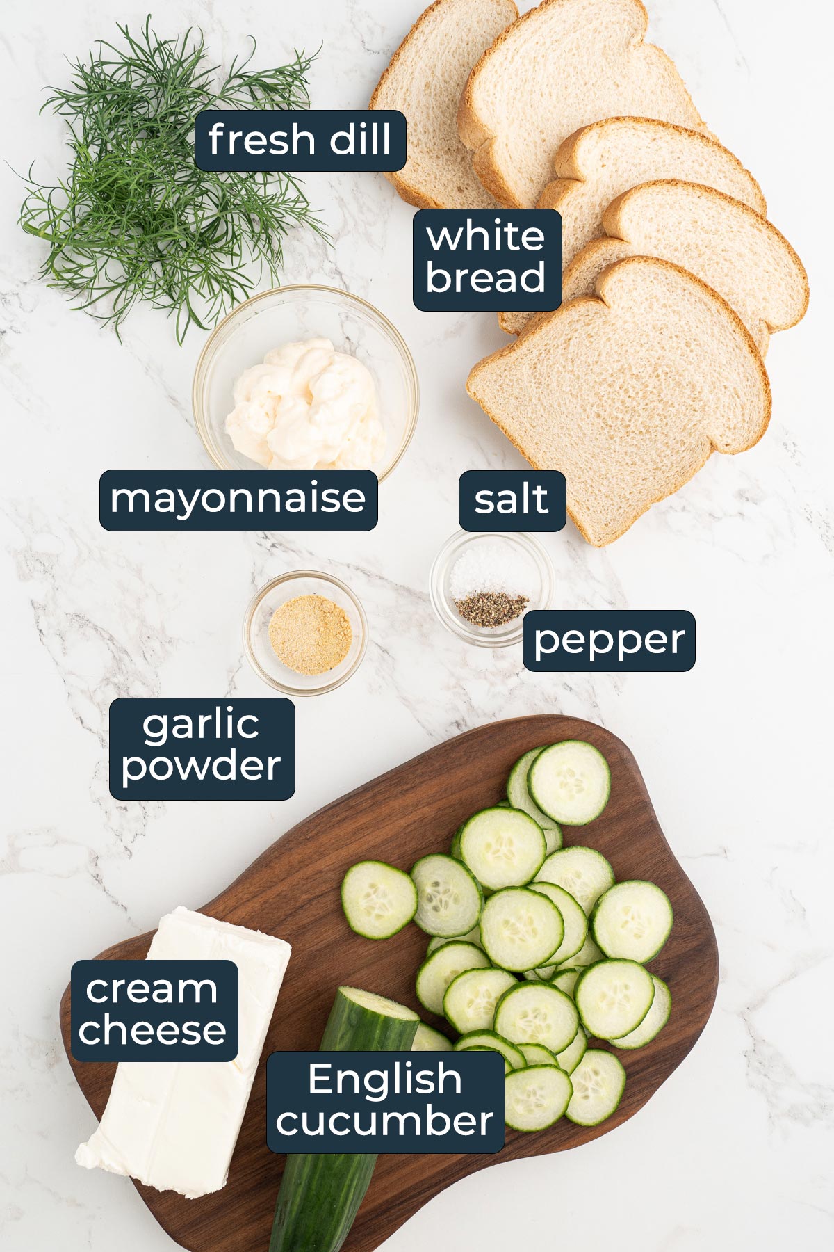 Ingredients for making cucumber sandwiches on a cutting board and in prep bowls.